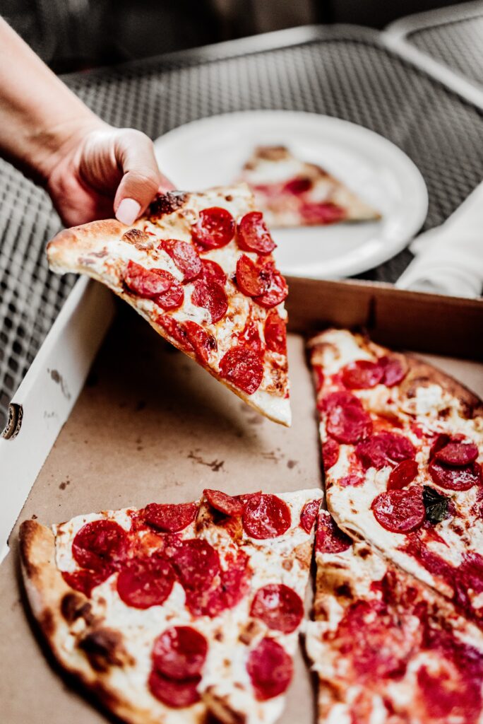 Hand grabbing slice of pizza